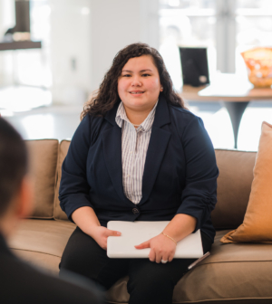 a student sitting with a laptop at a business meeting