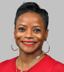 Headshot of Pamela Moye wearing a red top, gold necklaces and gold earrings.