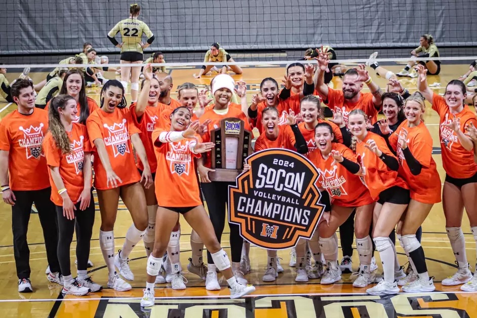 Women's volleyball team poses with conference champion trophy