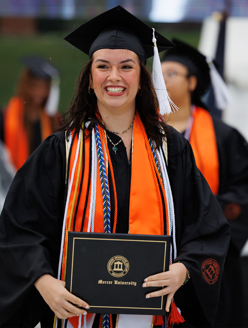 Woman at graduation holding her diploma