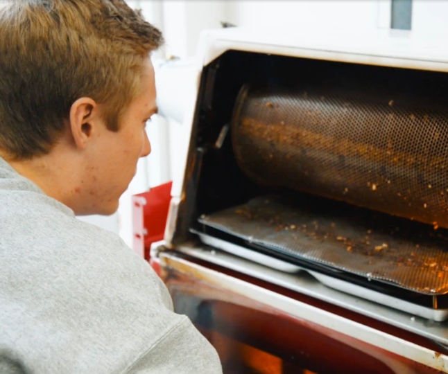 A Mercer student roasting coffee beans.