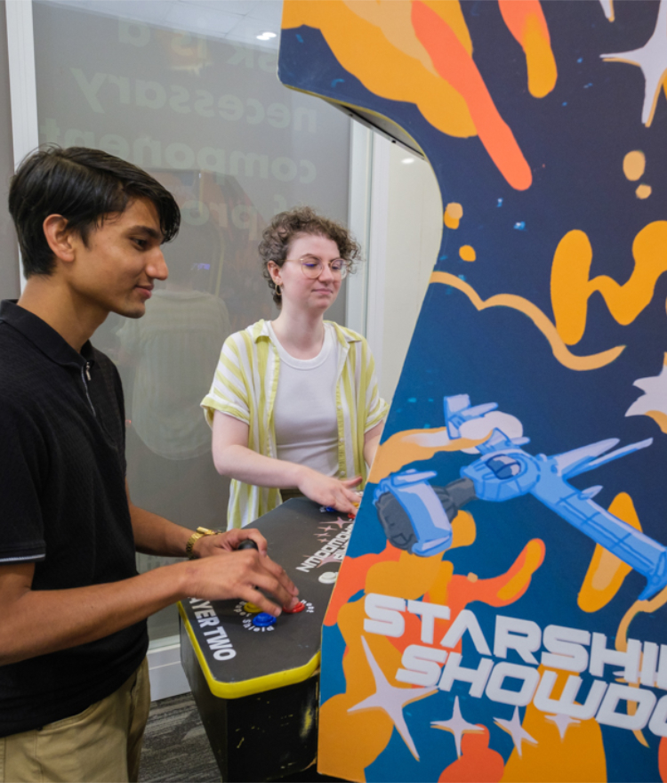 Mercer students Rajwol Chapagain and Maret McWhorter play an arcade video game.