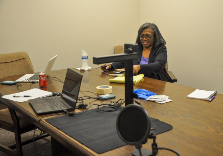 A graduate research assistant sets up recording technology.